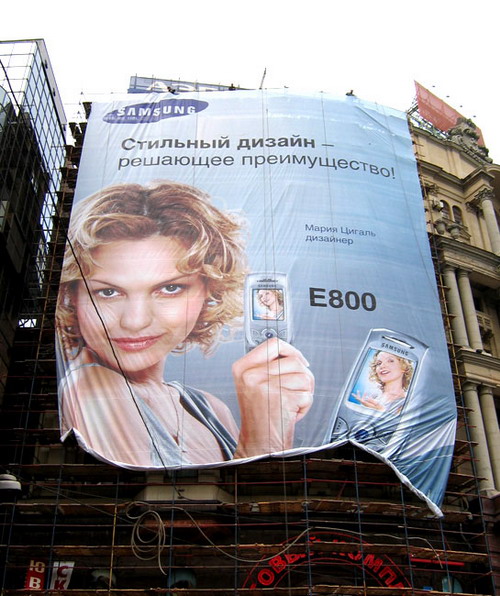 Рекламный баннер на фасаде со строительными лесами
